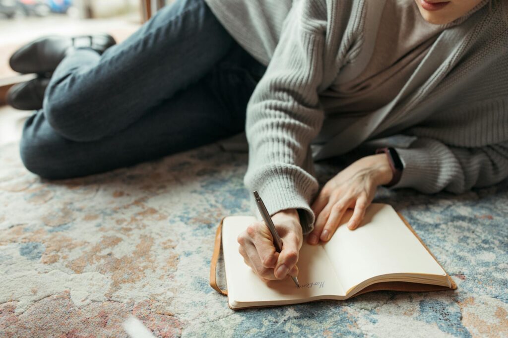 A photograph of a person documenting their pain and suffering in a journal. — pain and suffering injury claims