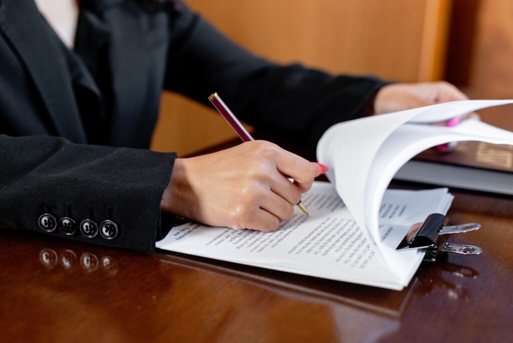 A close-up of a lawyer reviewing legal documents related to choosing injury lawyer.