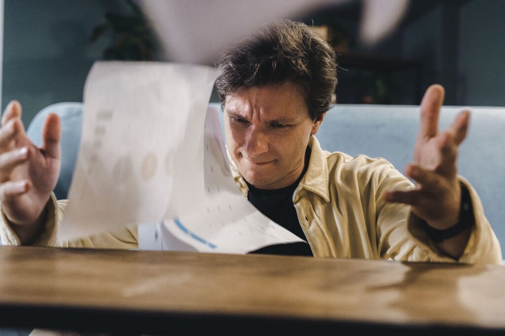 An image of a frustrated person dealing with insurance paperwork. — injury claim delay reasons