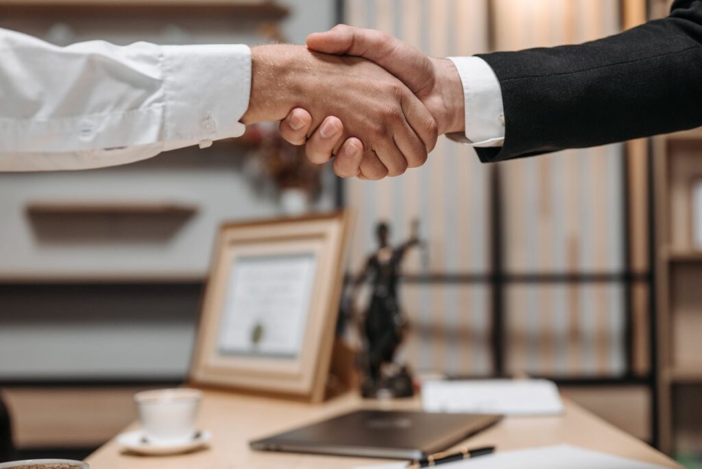 An image of a satisfied client shaking hands with their injury lawyer after a successful settlement. — injury lawyer needed