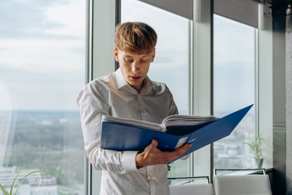 Insurance adjuster reviewing a claim file in an office setting. — insurance adjuster role
